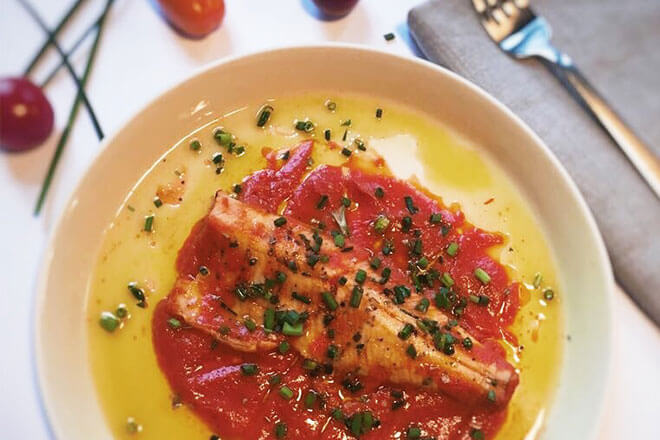 Köstliches Fischfilet mit Tomatensauce, Schnittlauch und frischen Tomaten.