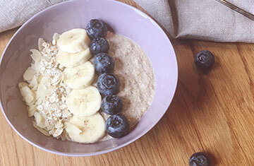 Leckere Smoothie Bowl mit Bananen und Heidelbeeren.