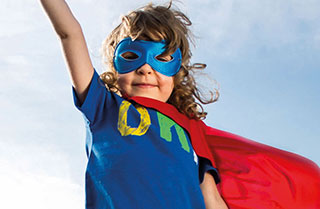 Ein junger Bub ist verkleidet als Superman. 